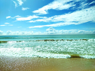 Waves breaking on the beach on a sunny day on Camburi, Vitória, Espírito Santo, Brazil.
