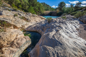 Horizontal photo of the source of Fuente Caputa, between rocks, in the town of Mula, Region of Murcia, Spain, between rocks and on a sunny day