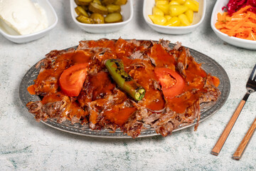iskender kebab. Traditional Turkish cuisine flavor with tomato sauce and butter. iskender kebab on gray background