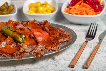 iskender kebab. Traditional Turkish cuisine flavor with tomato sauce and butter. iskender kebab on gray background