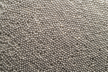 Texture of small metallic silver balls top view.