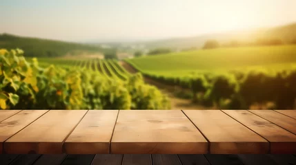 Fotobehang Wood table top with a glass of wine on blurred vineyard landscape background, for display or montage your products. Agriculture winery and wine tasting concept © Michel 