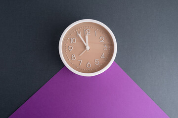 White alarm clock on a colored background. Fashionable minimalist style. Time, business and technology concept. Flat composition. View from above
