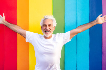 Glücklicher Senior vor Regenbogenfarben 