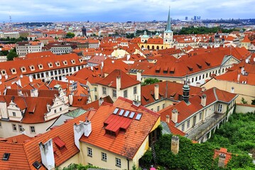 Fototapeta na wymiar Prague, Czech Republic. Mala Strana, Old Town of Prague. Top view of downtown, panorama. Ancient old buildings with red tiled roofs, church, tower