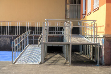 Rampway with stainless steel handrail for support wheelchair-disabled people. Health care concept.metallic stair railing outside the building