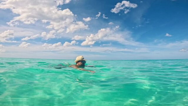 Man swimming in transparent blue water of Caribbean sea in Varadero, Cuba