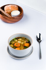 Fresh chicken broth with meatballs, noodles, potato gnocchi and microgreens.