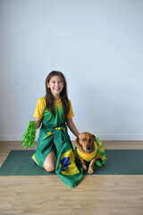 menina sorridente com cachorro doméstico com roupas do brasil 