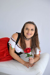 linda mulher Empregada camponesa vestida para oktoberfest, tradicional festa alemã segurando rosa...