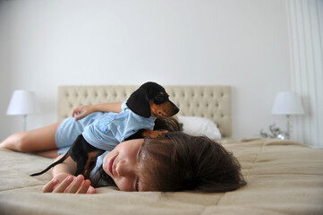 menina criança feliz a vontade em casa com cachorro de estimação filhote fofo de Dachshund 