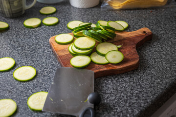 Chopped courgette slices on a wooden cutting board
