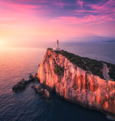 Aerial view of lighthouse on the mountain at colorful sunset in summer. Beautiful lighthouse on the...