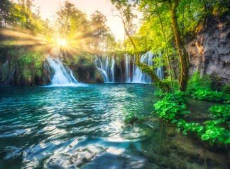 Waterfall in green forest in Plitvice Lakes, Croatia at sunset in summer. Colorful landscape with...