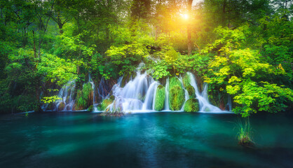 Fototapeta na wymiar Waterfall in green forest in Plitvice Lakes, Croatia at sunset
