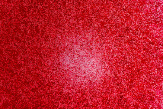 Bubbles on the surface of the drink of red raspberries soda drink on background. Fresh drink of scarlet cranberry or cherry or red currant or viburnum, closeup, top view
