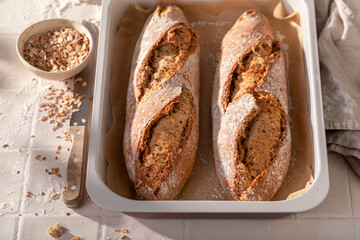 Homemade baguettes baking in with grain and ears.