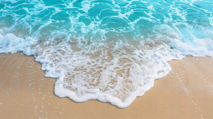 Fototapeta na wymiar Soft wave of the sea on the sandy beach. Summer background.