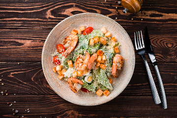 Italian cuisine Caesar salad with shrimps, parmesan cheese, lettuce, cherry tomatoes and croutons.