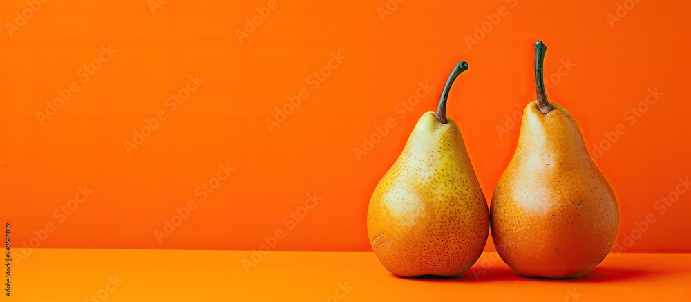 Poster two ripe pears are placed on a vibrant orange background with a striking red backdrop in a high-reso