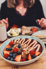 Gesundes, veganes Frühstück mit frischen Früchten, Soja-Joghurt, Granola und Erdnussmus