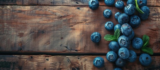 A collection of ripe blueberries arranged neatly on a rustic wooden table. The blueberries are fresh and vibrant, showcasing their natural colors against the warm wood backdrop. - obrazy, fototapety, plakaty