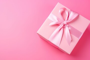 A beautifully wrapped pink gift box with a satin ribbon on a matching pink background, ideal for special occasions.