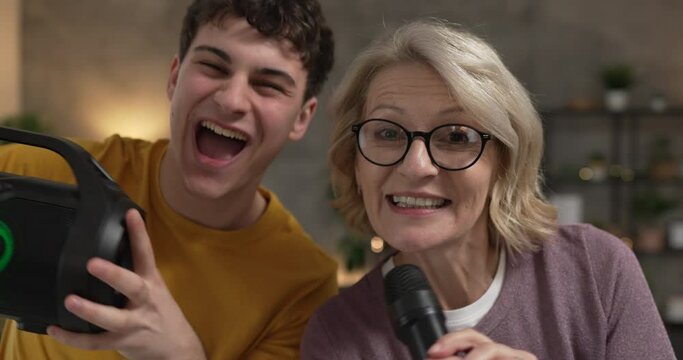 mother and son mature woman teenage man happy smile sing dance at home