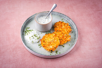 Traditional parsnip potato pancakes with chives and quark dip served as close-up on a Nordic Design plate with text space