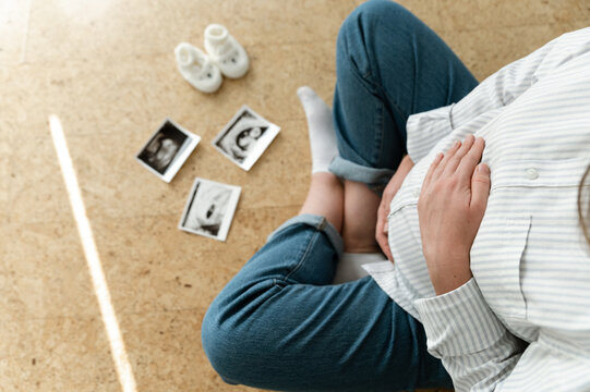 top view of a pregnant woman's belly. Ultrasound image of a pregnant woman. expecting a child. close-up of the belly of a pregnant woman sitting on the floor inside the house