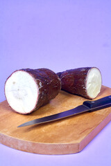 Fresh Organic Cassava Root, Manioc Esculenta, yuca On purple Background