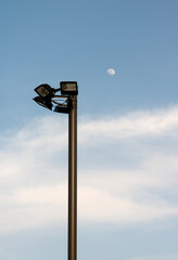 View of a street lamp and the white moon in the sky