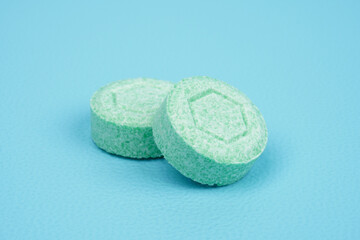 One green colored tablet against blue background