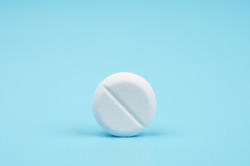 Few white tablets against blue background