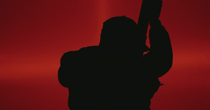 Silhouette Man with Weapon. Silhouette Man with Gun with red background. A silhouette of a man holding a weapon, set against a vivid red background, creates a striking and intense visual. 