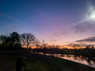 Sunset over the pond at the Northfield Hills Condo association at the corner of Long Lake Road and Coolidge Highway in Troy, Michigan, a suburb of Detroit partly cloudy winter day