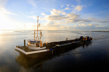 Dredger vessel in the Wadden Sea preventing the fairway from silting up