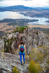 Naklejka premium hiker girl admires the panorama of moogerah national park from the top of mount greville, hiking in south east queensland near brisbane and gold coast