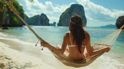 Summer travel vacation concept,rear view of a Happy traveler Asian woman with a white bikini relaxing in hammock on beach in Thailand