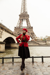 sexy girl posing in front of the elf tower. A model in a red beret and jacket walks through Paris. city ​​of lovers. visit to paris