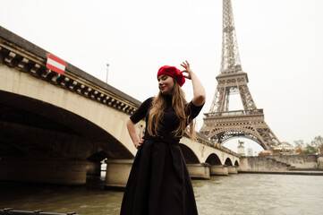 sexy girl posing in front of the elf tower. A model in a red beret and jacket walks through Paris. city ​​of lovers. visit to paris