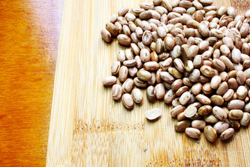 Carioca beans scattered on the cutting board. Brazilian grains.