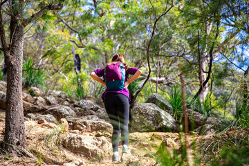 brave fit girl hiking through the bush to the top of mount maroon; rock scrambling in mount barney...