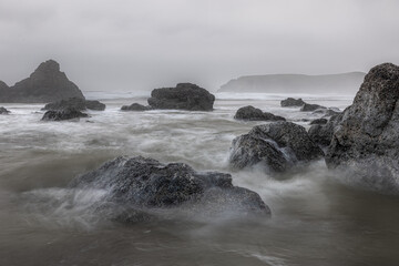 A rocky shoreline with a large body of water in the background
