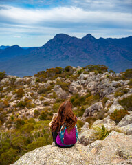 back view of hiker girl sitting at the top of mount maroon and admiring the panorama of famous...