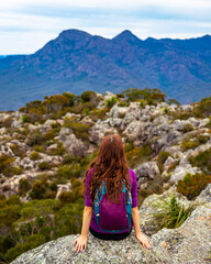 back view of hiker girl sitting at the top of mount maroon and admiring the panorama of famous...