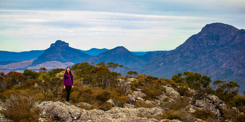 backpacker girl celebrating successful hike to the summit of mount maroon; rock scrambling in mount...
