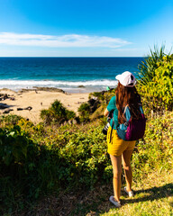 girl looking for whales from the cliffs of point danger above duranbah beach in coolangatta near...