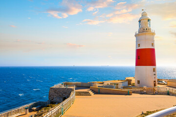 Fototapeta na wymiar The red and white lighthouse at Europa Point, also known as Trinity Lighthouse near the Rock of Gibraltar, in the UK Territory, along the Mediterranean Sea. 