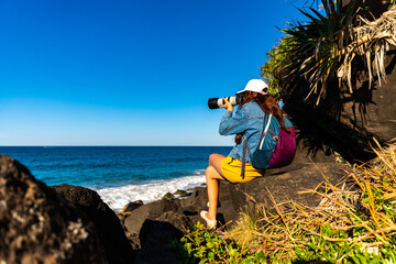 girl looking for whales from the cliffs of point danger above duranbah beach in coolangatta near gold coast, queensland, australia; relaxing coastal walk in a scenic area